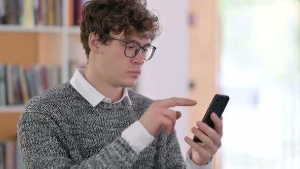 Portret młodego człowieka używającego smartfona - Materiał filmowy, wideo
