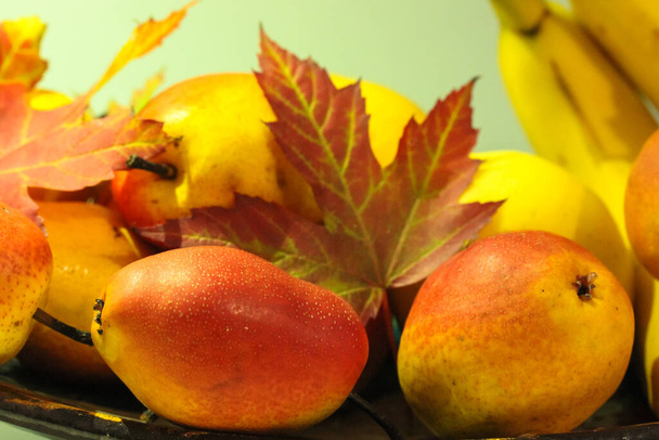 Autumn still life, ripe juicy pears and close-up maple leaves - Photo, Image