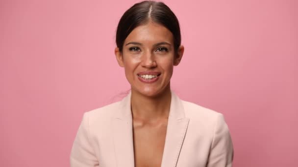 gelukkig jong zakenvrouw in roze pak verbergen achter blauw spaarvarken bank en het maken van duimen tot gebaar op roze achtergrond - Video