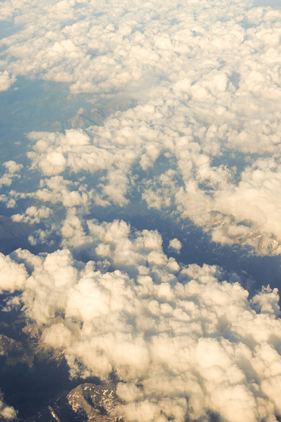 Avrupa 'da bir uçak penceresinden görülen Avusturya Alp Dağları karla kaplı bulutlar - Fotoğraf, Görsel