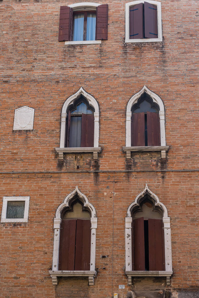 Italie, Venise, anciennes fenêtres sur un bâtiment rouge - Photo, image