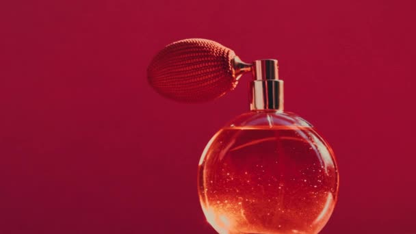 Vintage perfume bottle and shining light flares on red background, glamorous fragrance scent as luxury perfumery product for cosmetic and beauty brand - Footage, Video