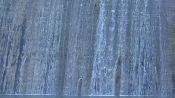 Woda wpadająca do wodospadu w ścianie do tamy na bagnach - Materiał filmowy, wideo