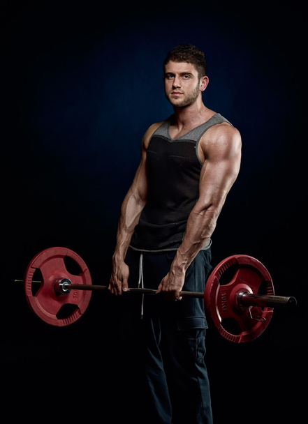 athletic young man lifting weights - Foto, imagen