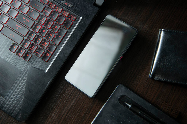 tablette portable pour téléphone portable pour la conception de portefeuille sur une table en bois noir très élégant et formel - Photo, image