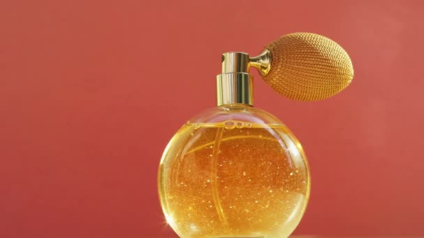 Altın parfüm şişesi ve parlayan ışık, şık bir koku kozmetik ve güzellik markası için lüks bir ürün.  - Video, Çekim