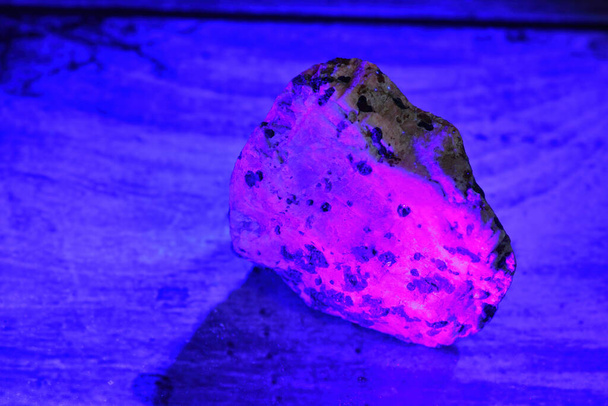 Mineral fluorescing pink under a UV light. - Photo, Image