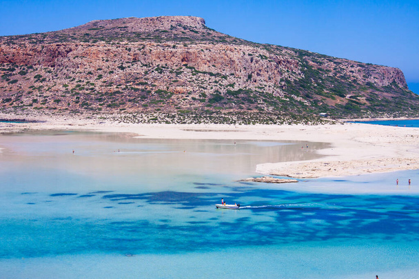 scenic view of Balos bay, crete, greece, in summer, white sand, sea and clear blue sky, tropical atmosphere a boat carries tourists - Photo, Image
