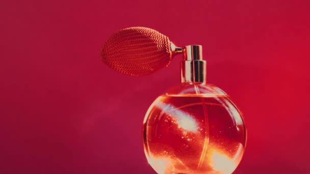 赤を基調としたヴィンテージ香水瓶と輝くライトフレア、化粧品や美容ブランドのための高級香水製品としての魅力的な香り - 映像、動画