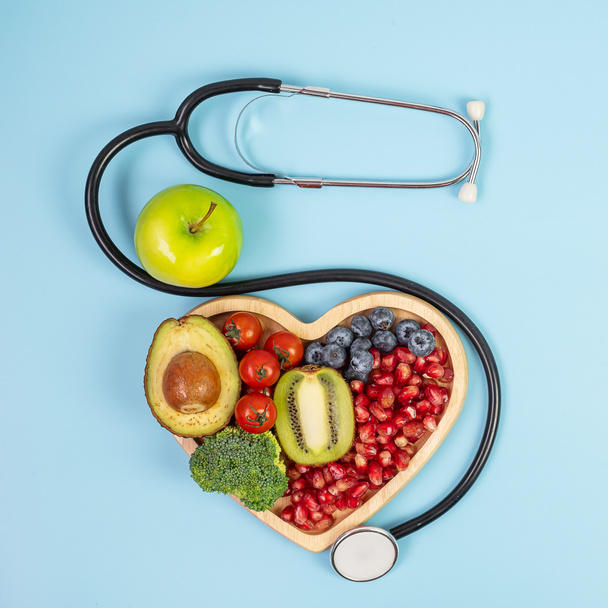 frutas e legumes; Mirtilos, tomate cereja, abacate, brócolis, Kiwi e maçã verde sobre fundo azul. perda de peso, nutrição, alimentação saudável, dieta e conceito vegetariano - Foto, Imagem