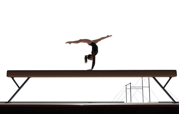 Samica gimnastyczki robi skomplikowaną sztuczkę na profesjonalnej arenie - Zdjęcie, obraz