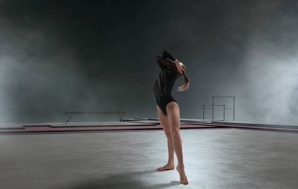 Vrouwelijke turnster doet een ingewikkelde truc in een professionele arena - Foto, afbeelding