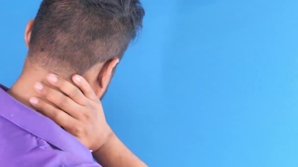 hombre que sufre de dolor de cuello aislado en azul  - Metraje, vídeo