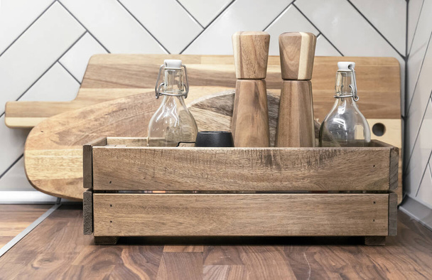 Caja de cocina de madera con recipientes de especias y botellas de vidrio para varios líquidos. - Foto, imagen