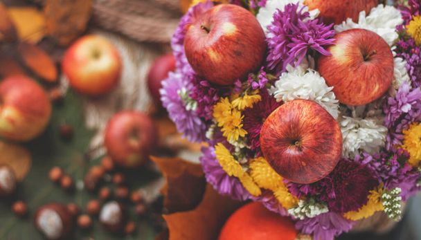 Autumn bouquet of flowers and apples. Autumn bright background with apples, chrysontema, dry leaves. September October November. Seasonal autumn background with yellow and orange colors. - Фото, зображення