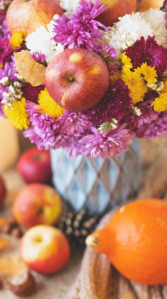 Autumn bouquet of flowers and apples. Autumn bright background with apples, chrysontema, dry leaves. September October November. Seasonal autumn background with yellow and orange colors. - Фото, зображення
