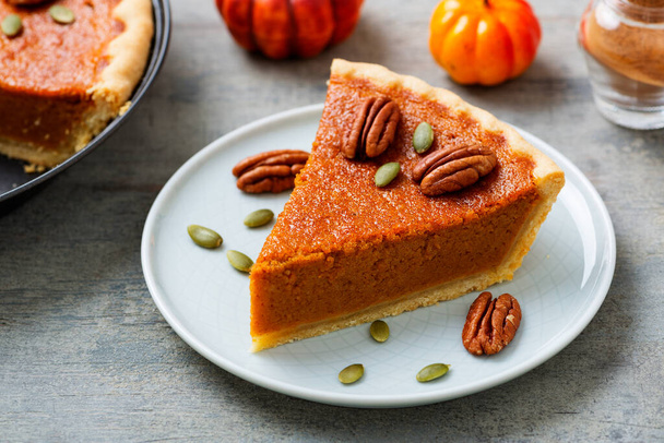 Festive Homemade Pumpkin Pie decorated with pecan nuts and pumpkin seeds. - Photo, Image