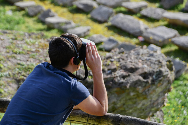 Persona observando las ruinas del Circo Massimo con una máscara de 360 viajes virtuales - Foto, imagen