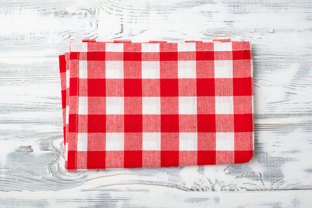 Top view of red checkered napkin on white wooden table. - Photo, Image