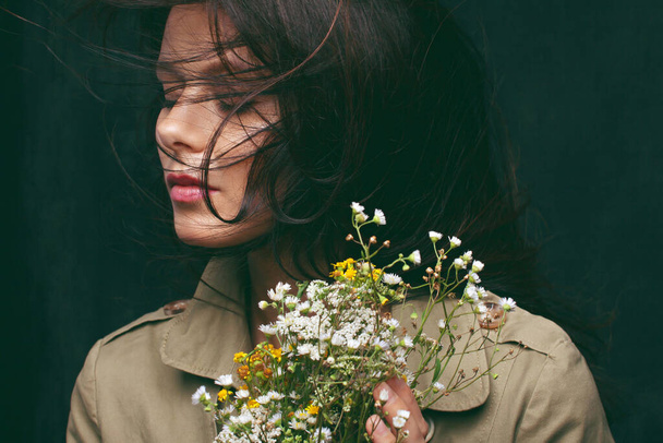 Portrait of a cute girl with a bunch of wild flowers. - Φωτογραφία, εικόνα