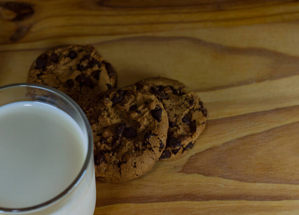 Cioccolato Chip biscotti e latte sul tavolo di legno - spazio copia - Foto, immagini