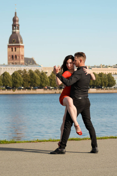 Νεαρό ζευγάρι χορεύει μαζί στο φόντο της παλιάς πόλης. Έννοιες ταξιδιών και τρόπου ζωής. Επιλεκτική εστίαση, σύλληψη πορτρέτου - Φωτογραφία, εικόνα