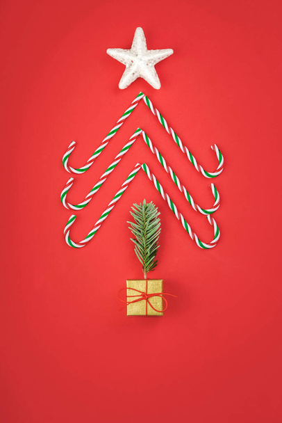 Feliz Natal.Concepção de Natal background.caramel bastões na forma de uma árvore de Natal em um fundo vermelho - Foto, Imagem