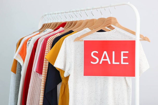 Clothes on the rail and a sale sign. Final sale, discounts - Foto, Imagen