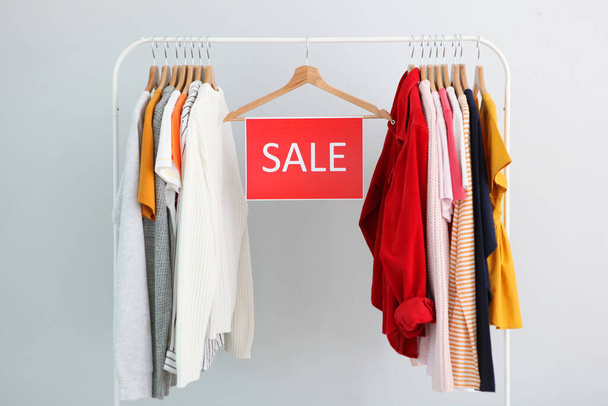 Clothes on the rail and a sale sign. Final sale, discounts - Photo, Image