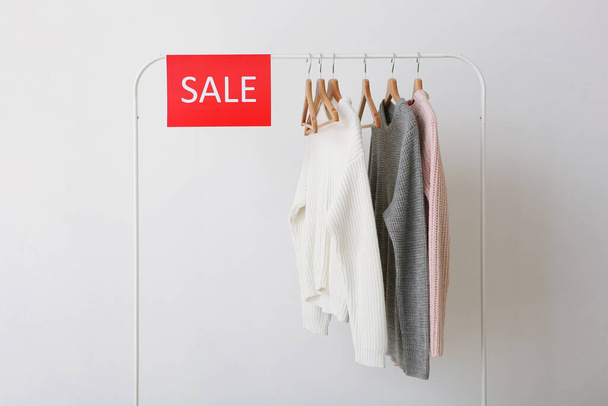 Clothes on the rail and a sale sign. Final sale, discounts - Zdjęcie, obraz