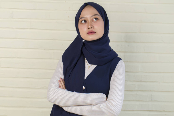 jonge aziatische moslim vrouw in hoofd sjaal glimlach met armen gekruist - Foto, afbeelding