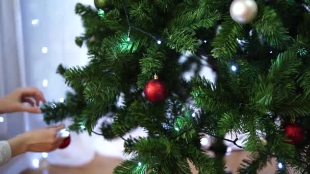 Primer plano de las manos de las mujeres, decorar el árbol de Navidad. - Metraje, vídeo