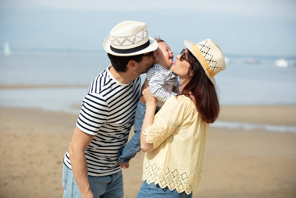 happy man woman and baby on the beach - 写真・画像