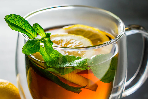 Čaj s citrónem a mátou v průhledném šálku. Alternativní léčivý přípravek pro léčbu. - Fotografie, Obrázek