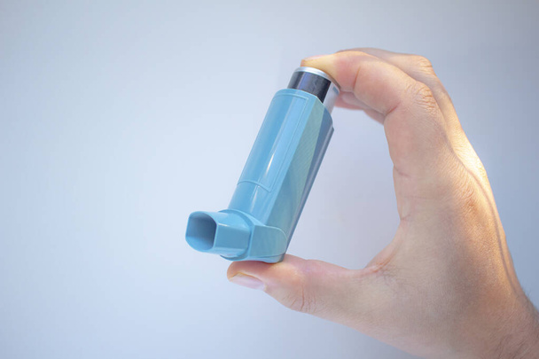 Людина, що тримає інгалятор астми на чистому тлі
 - Фото, зображення