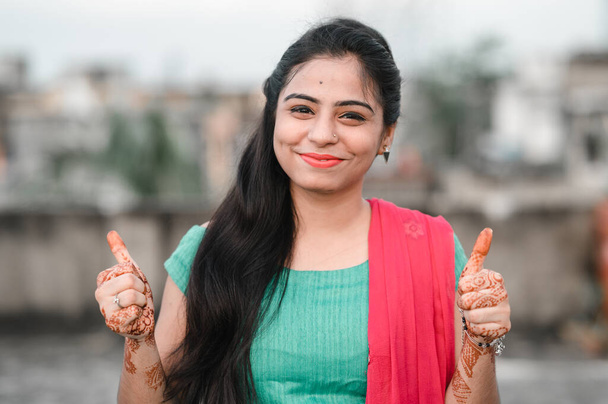 Closeup portrait of young woman with two thumbs up sign gesture, isolated outdoors background. Positive emotion facial expression feelings, signs and symbols, body language. - Photo, Image