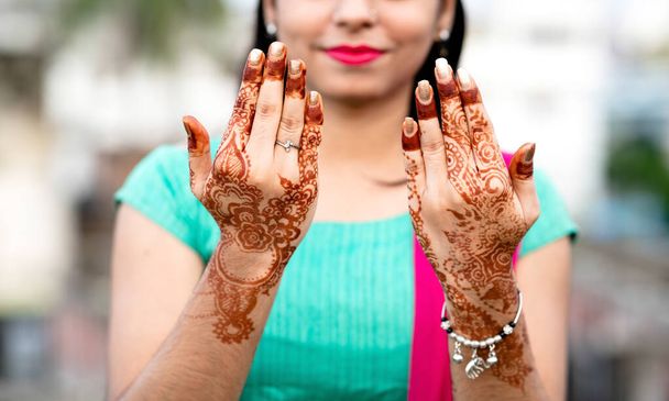 Porträt einer jungen Inderin in lässigem Stil mit Mehendi oder Henna-Design an beiden Händen - Foto, Bild