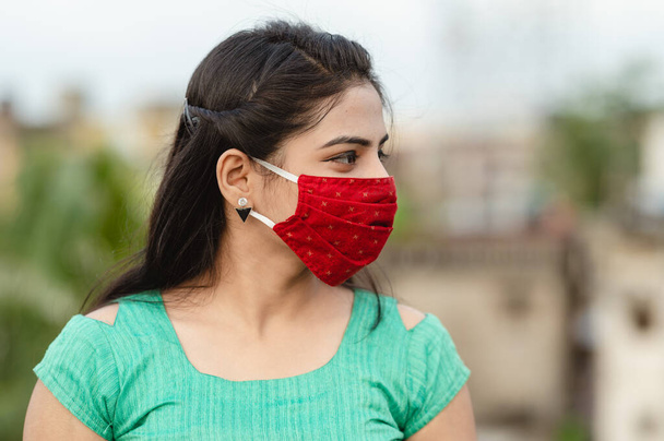 Όμορφη χαμογελαστή Ινδή νεαρή γυναίκα με προστατευτική μάσκα προσώπου, ευτυχισμένη χιλιετή γυναίκα στην ιατρική κάλυψη προσώπου από την COVID-19, έννοια υγειονομικής περίθαλψης, απομονωμένη σε εξωτερικό φόντο - Φωτογραφία, εικόνα