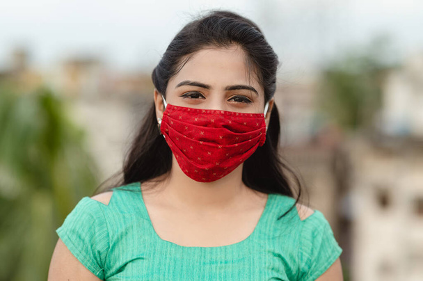 Όμορφη χαμογελαστή Ινδή νεαρή γυναίκα με προστατευτική μάσκα προσώπου, ευτυχισμένη χιλιετή γυναίκα στην ιατρική κάλυψη προσώπου από την COVID-19, έννοια υγειονομικής περίθαλψης, απομονωμένη σε εξωτερικό φόντο - Φωτογραφία, εικόνα