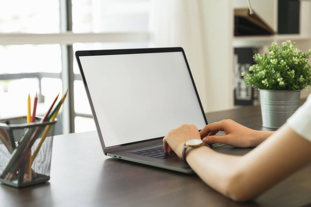Nő használt laptop fehér képernyő és írószer az asztalon a házban. - Fotó, kép