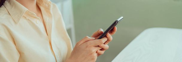 Close-up van jonge vrouw hand vasthouden smartphone en chatten met vrienden op het sociale netwerk. - Foto, afbeelding