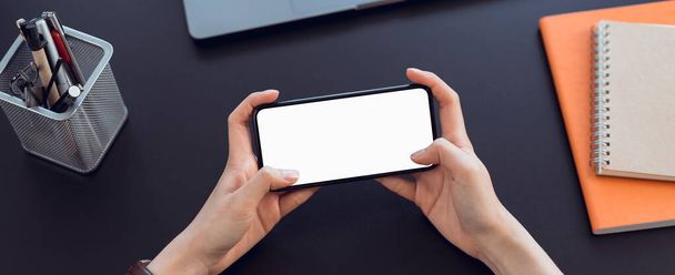 Closeup of young woman hand holding smartphone on the table and the screen is blank, social network concept.	 - Photo, image