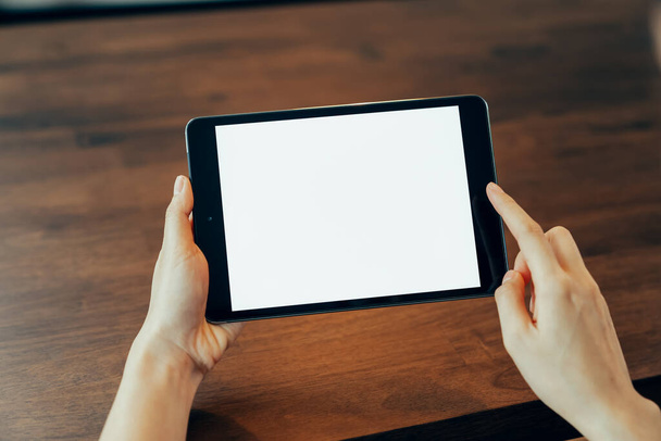 Detailní záběr ženské ruky držící digitální tablet na stole a obrazovka je prázdná. - Fotografie, Obrázek