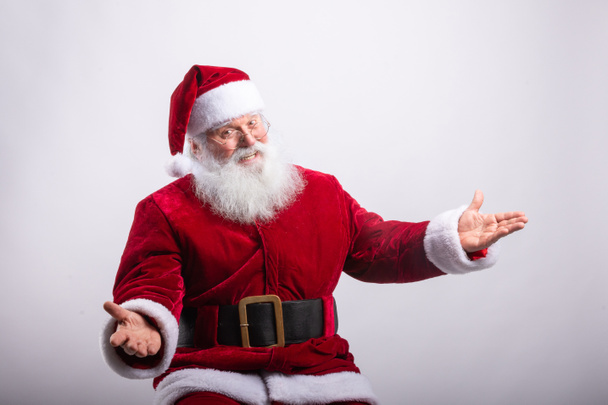 Glücklicher Weihnachtsmann, saß mit offenen Armen vor weißem Hintergrund - Foto, Bild