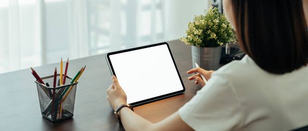 Großaufnahme einer Frau, die ein digitales Tablet auf dem Tisch hält und der Bildschirm ist leer. - Foto, Bild