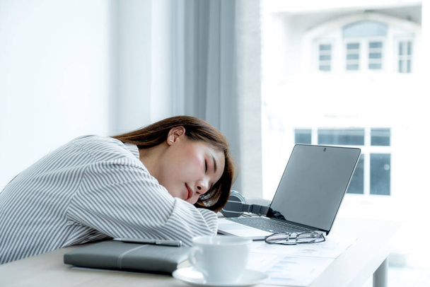 Triste mujer de negocios asiática empleada infeliz trabajando con aburrido en el portátil y gráfico en la oficina cansado, concepto de síndrome de oficina. - Foto, Imagen