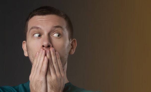 surprised man closing his mouth with his hand - Photo, Image