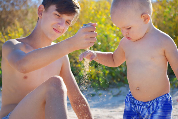 Ребенок играет на песке у моря - Фото, изображение