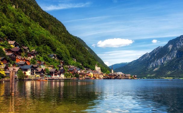 Veduta del famoso villaggio di Hallstatt che si riflette nel lago di Hallstattersee nelle Alpi austriache in bella luce del mattino in una giornata di sole in estate, regione di Salzkammergut, Austria. - Foto, immagini