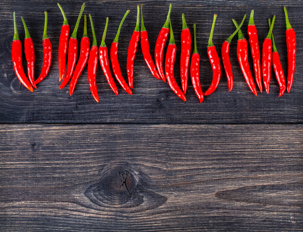 bovenaanzicht van pittige rode chili peper op houten ondergrond.Selectieve focus - Foto, afbeelding